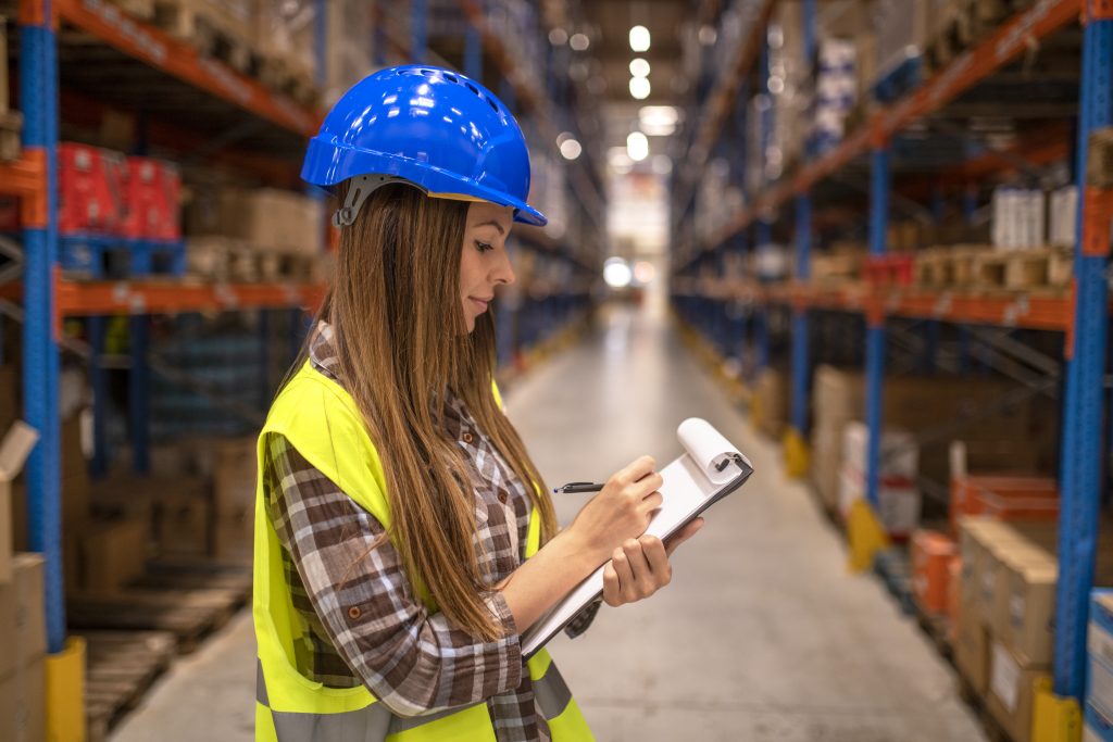 Operario gestionando logística de almacén con tablet en entorno industrial moderno (Gestión logística de almacenes)